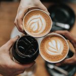 Young people's hands holding coffee cups
