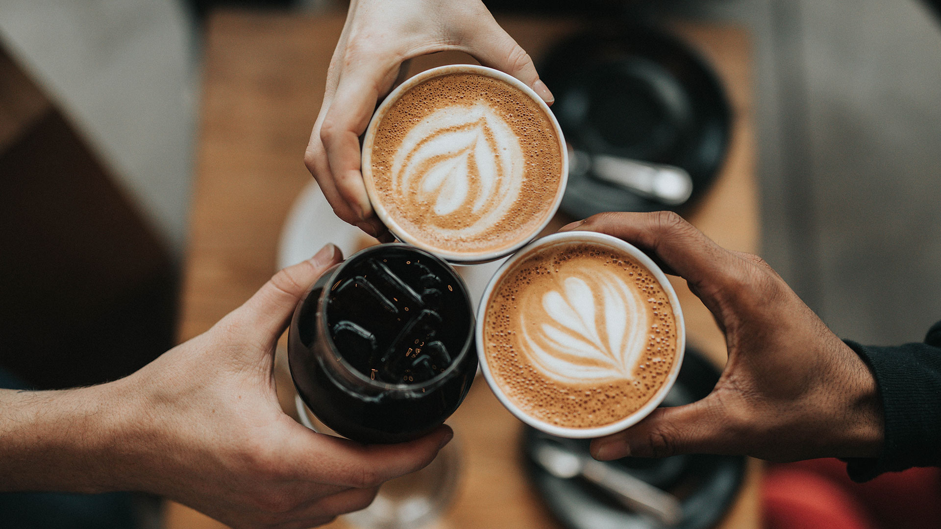 Young people's hands holding coffee cups